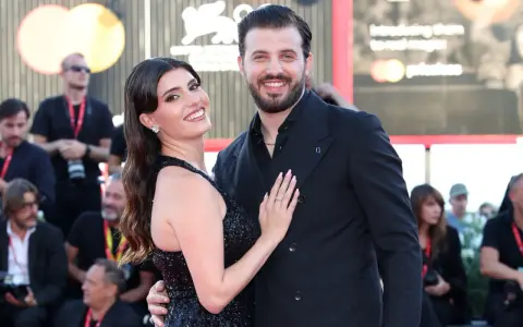 Gaetano Migliaccio e la sua compagna sorridono sul red carpet, un momento di gioia che ricorda la spensieratezza di "Mare Fuori".