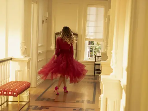 E così, con un vortice di tulle rosso, una donna balla in un corridoio luminoso.