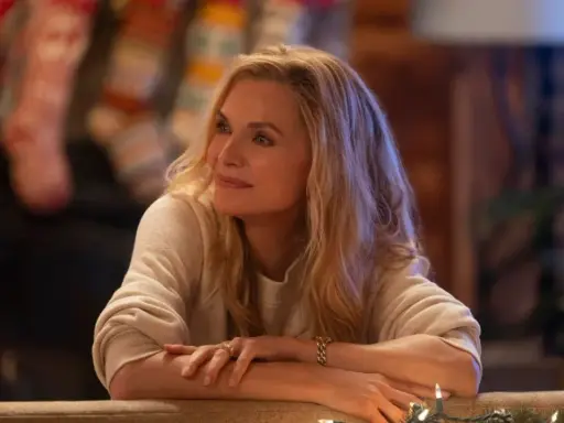 Michelle Pfeiffer in un film natalizio, con calze appese al camino e luci scintillanti.