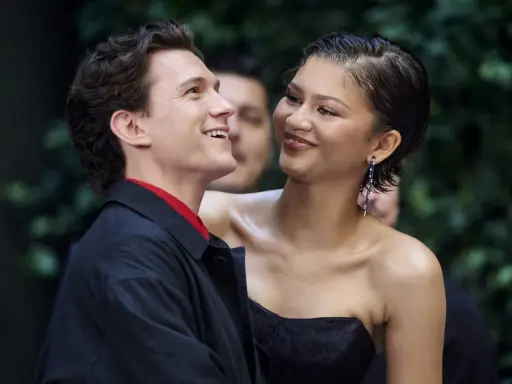 Tom Holland e Zendaya, un momento di complicità sul red carpet. Lei sorride guardandolo, lui ricambia con un sorriso radioso.