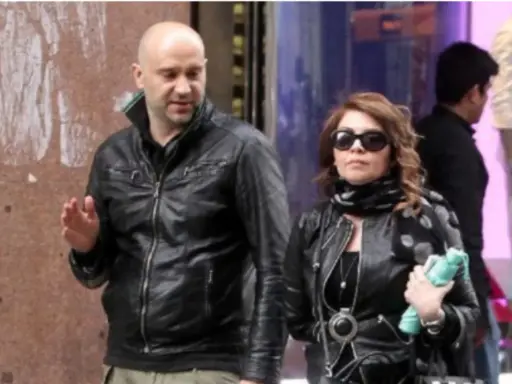 Cristina D'Avena passeggia con quello che sembra essere il suo marito, entrambi vestiti di pelle nera.