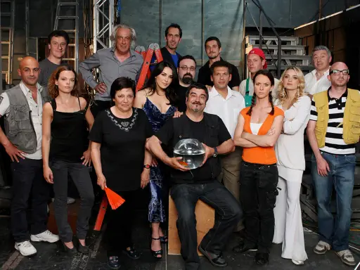 Il cast di Boris posa per una foto di gruppo, con un uomo che tiene una boccia con un pesce rosso.