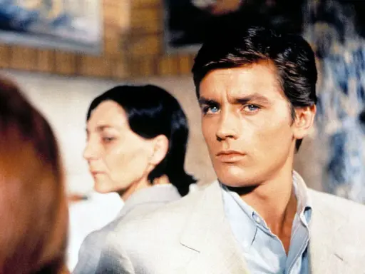 Alain Delon, icona di stile, in una scena che evoca i suoi film più belli. Sguardo intenso, fascino intramontabile.