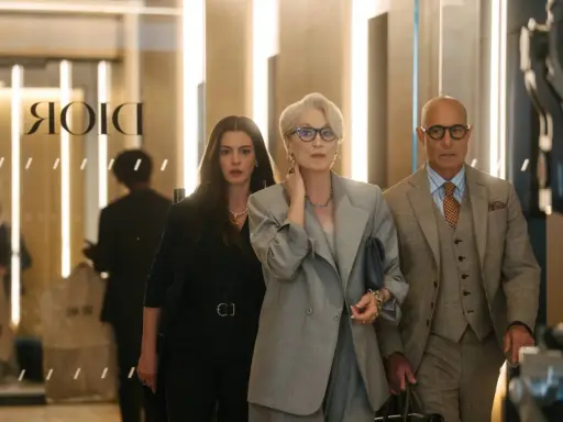 Anne Hathaway, Meryl Streep e Stanley Tucci camminano in un ambiente elegante, forse una boutique di lusso a Milano, ricordando "Il diavolo veste Prada 2".