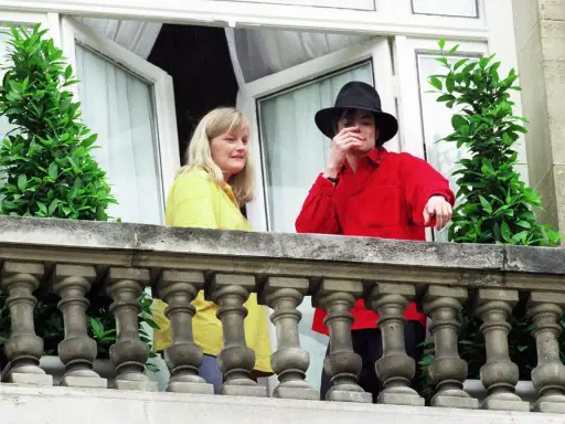 Michael Jackson con un cappello nero e una camicia rossa, accanto a una donna bionda. Forse la sua moglie?