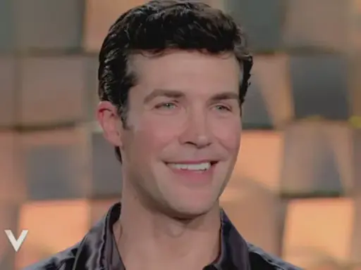 Roberto Bolle smiles, looking to the side.