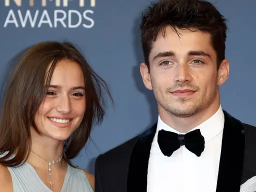 Charles Leclerc e la sua fidanzata sorridono sul red carpet.