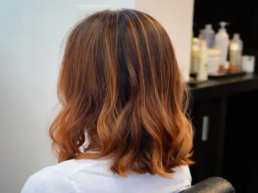 Capelli castani con riflessi ramati, un taglio di capelli un po più lungo del caschetto, leggermente mossi.