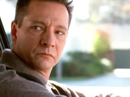 Primo piano di Chris Cooper, uno dei volti del cast di American Beauty, mentre guida.