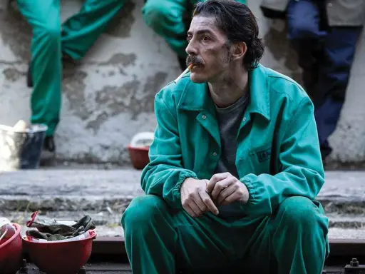 Michele Riondino in tuta verde, un'immagine che evoca scene dai suoi film e programmi TV.
