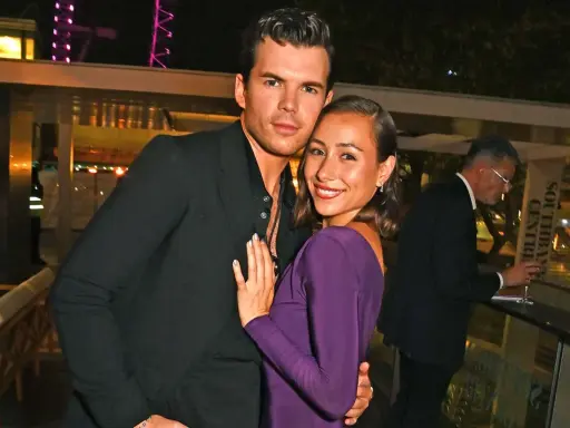 Luke Newton e la sua fidanzata, sorridenti e abbracciati, in un evento serale.