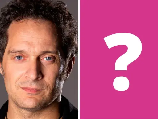 Primo piano di Claudio Santamaria, con un punto interrogativo rosa a destra. Forse si cerca la sua ex moglie?