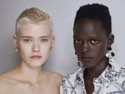 Due modelle con tagli cortissimi rasato pixie cut corto. Una con capelli biondi e orecchini dorati, l'altra con capelli neri e orecchini pendenti.