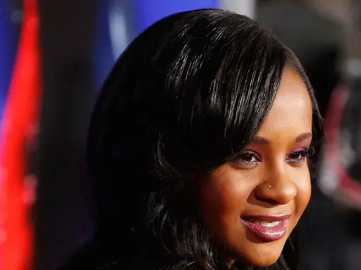 La figlia di Whitney Houston, Bobbi Kristina Brown, sorride con un trucco viola e capelli scuri.