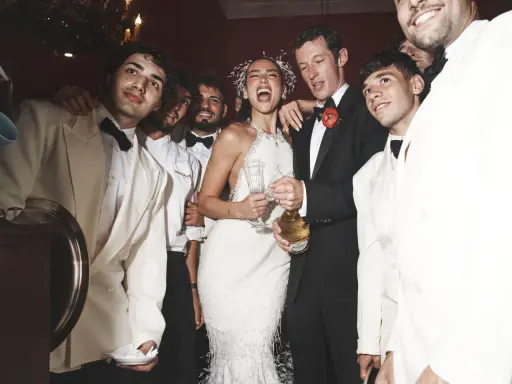 Dua Lipa festeggia il suo matrimonio con amici in abiti eleganti, champagne alla mano.