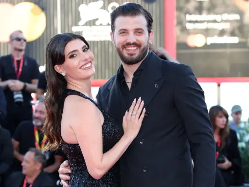 Gaetano Migliaccio e la sua compagna sorridono sul red carpet, un momento di gioia che ricorda la spensieratezza di "Mare Fuori".