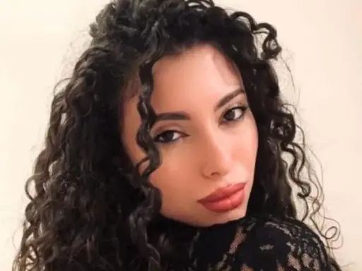 La nuova fidanzata di Raimondo Todaro, con lunghi capelli ricci e labbra rosse, posa con un abito di pizzo nero.
