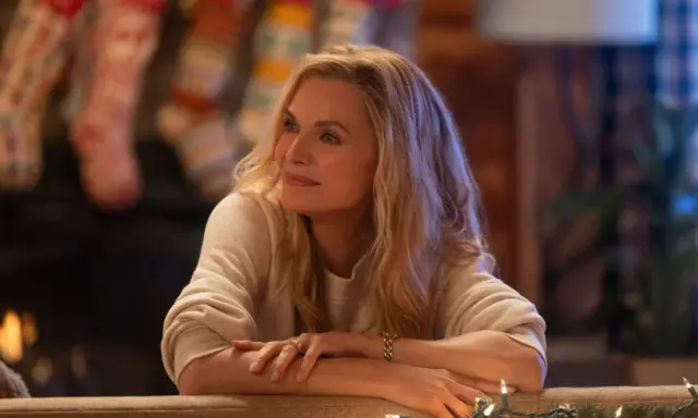 Michelle Pfeiffer in un film natalizio, con calze appese al camino e luci scintillanti.