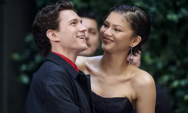 Tom Holland e Zendaya, un momento di complicità sul red carpet. Lei sorride guardandolo, lui ricambia con un sorriso radioso.