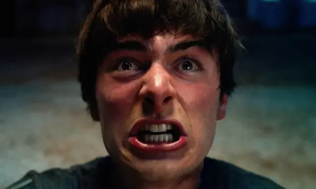 Un primo piano terrificante di un giovane con gli occhi spalancati e la bocca aperta, pronto ad affrontare le minacce di Stranger Things 5.