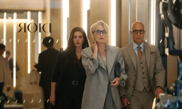 Anne Hathaway, Meryl Streep e Stanley Tucci camminano in un ambiente elegante, forse una boutique di lusso a Milano, ricordando "Il diavolo veste Prada 2".