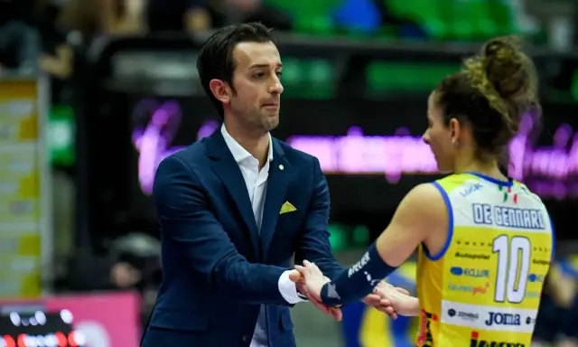 Santarelli de Gennaro, allenatore, stringe la mano a una giocatrice di pallavolo con la maglia numero 10.