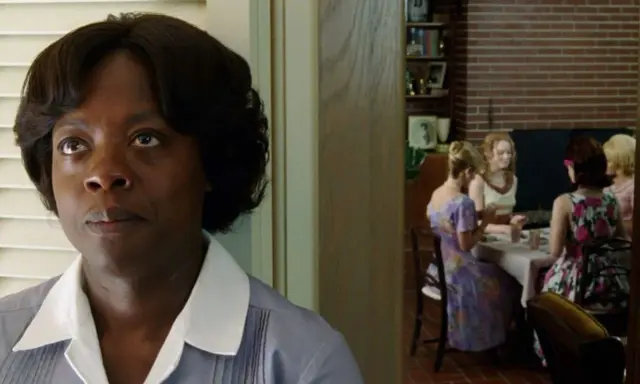 Viola Davis, nel cast di The Help, osserva un gruppo di donne riunite a tavola.