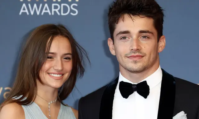Charles Leclerc e la sua fidanzata sorridono sul red carpet.
