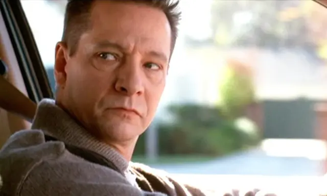 Primo piano di Chris Cooper, uno dei volti del cast di American Beauty, mentre guida.