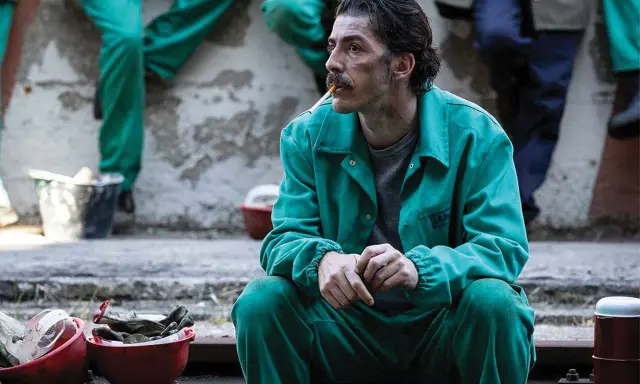 Michele Riondino in tuta verde, un'immagine che evoca scene dai suoi film e programmi TV.