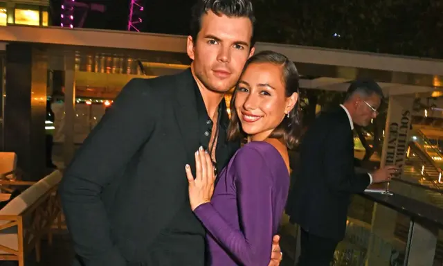Luke Newton e la sua fidanzata, sorridenti e abbracciati, in un evento serale.