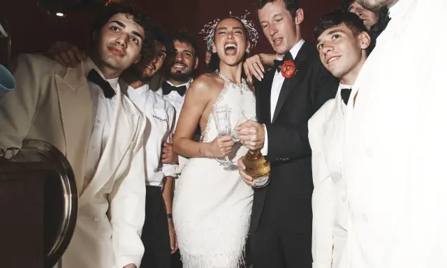 Dua Lipa festeggia il suo matrimonio con amici in abiti eleganti, champagne alla mano.