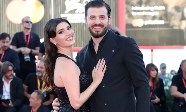 Gaetano Migliaccio e la sua compagna sorridono sul red carpet, un momento di gioia che ricorda la spensieratezza di "Mare Fuori".
