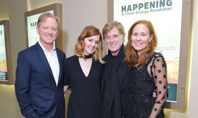 Robert Redford con i suoi figli, un momento di famiglia davanti a un poster su un'energia pulita.