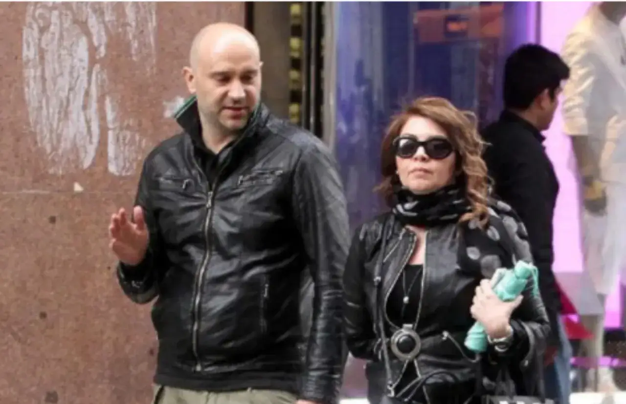 Cristina D'Avena passeggia con il suo compagno, entrambi vestiti di pelle nera.