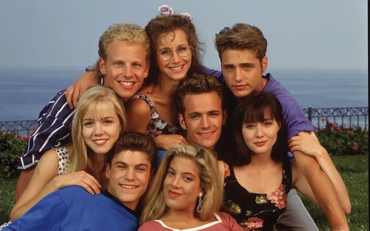 Il cast di Beverly Hills 90210, un gruppo di amici sorridenti e alla moda, posa insieme per una foto iconica.