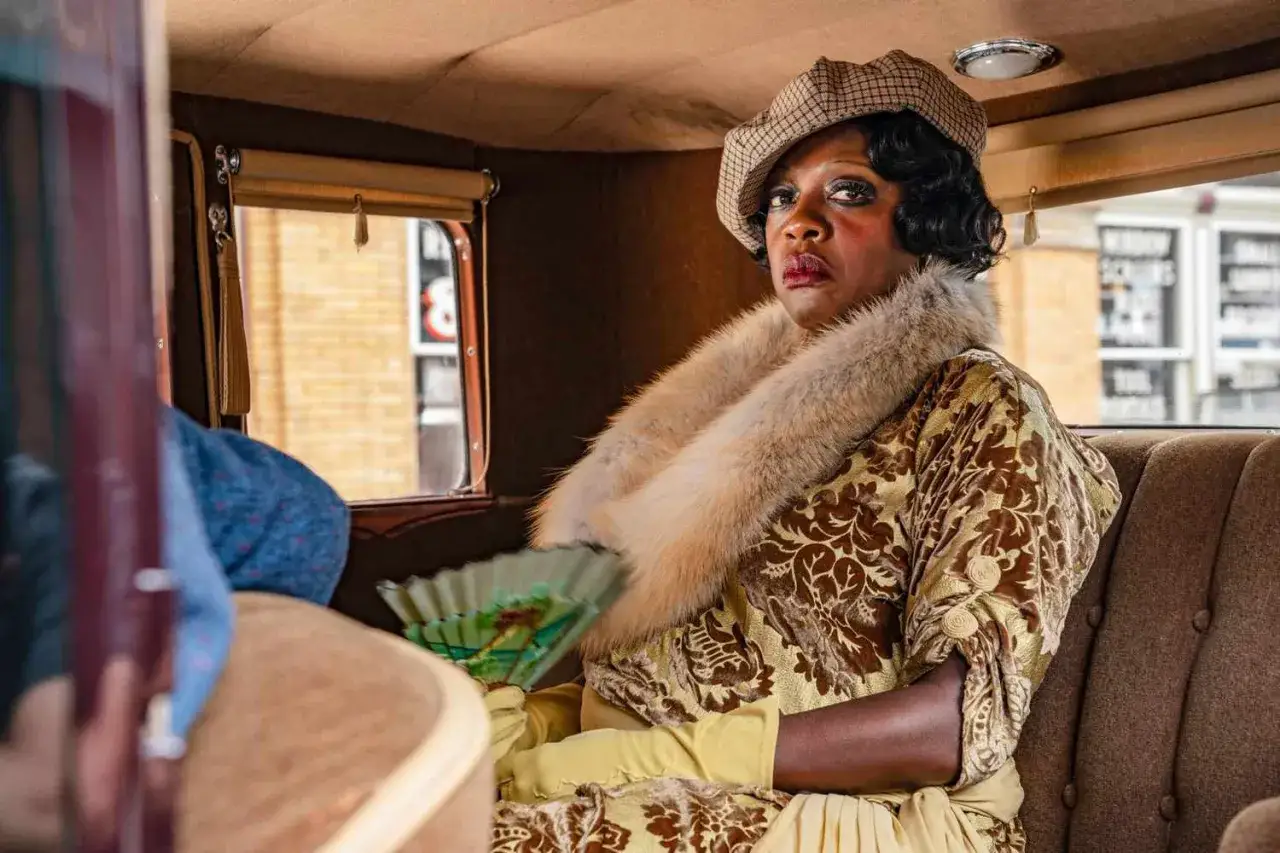 Viola Davis in un'auto d'epoca, con pelliccia e ventaglio, un'icona dei film e programmi TV.