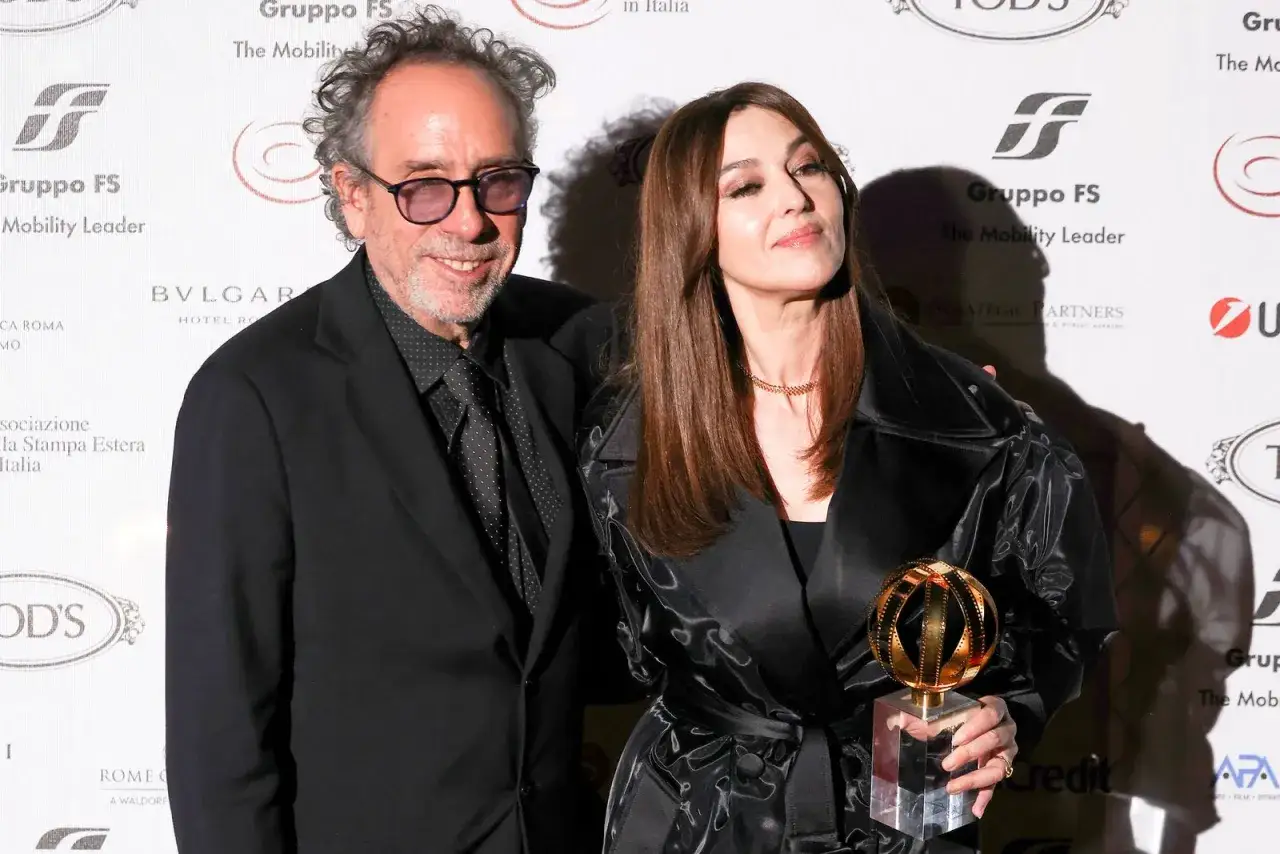 Monica Bellucci con il suo compagno Tim Burton, entrambi eleganti, celebrano un premio.