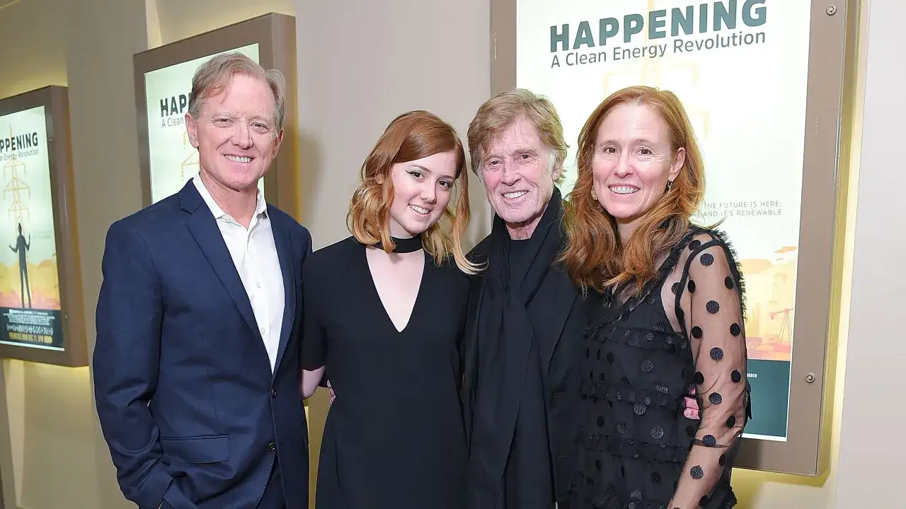 Robert Redford con i suoi figli, un momento di famiglia davanti a un poster sul futuro dell'energia.