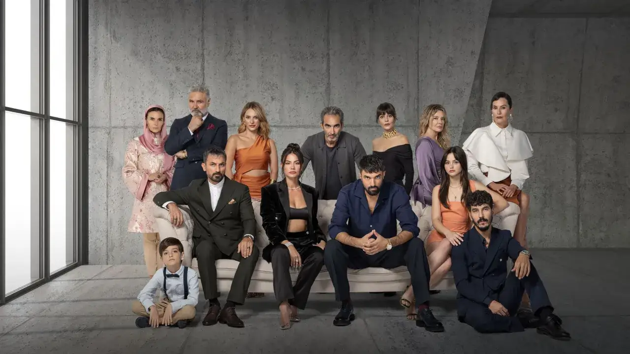 Il cast di una serie TV, tra cui io sono Farah, posa con eleganza su un divano e a terra, con uno sfondo moderno.