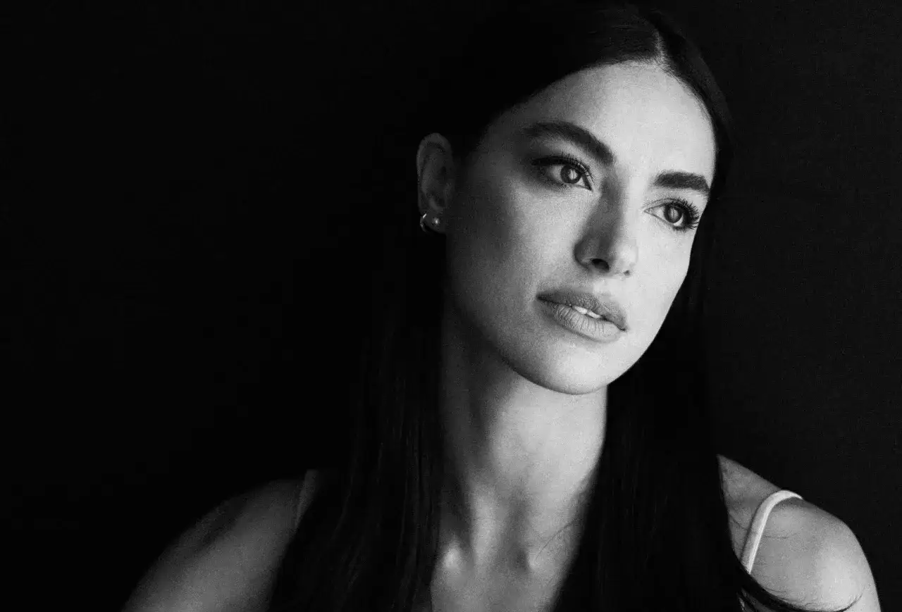 Ritratto in bianco e nero di Desirée Popper, con uno sguardo intenso. Potrebbe essere un'immagine promozionale per i suoi film e programmi TV.