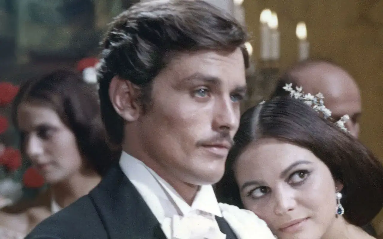 Alain Delon, icona di stile, in una scena che evoca i suoi film pi&ugrave; belli. Un'eleganza senza tempo.