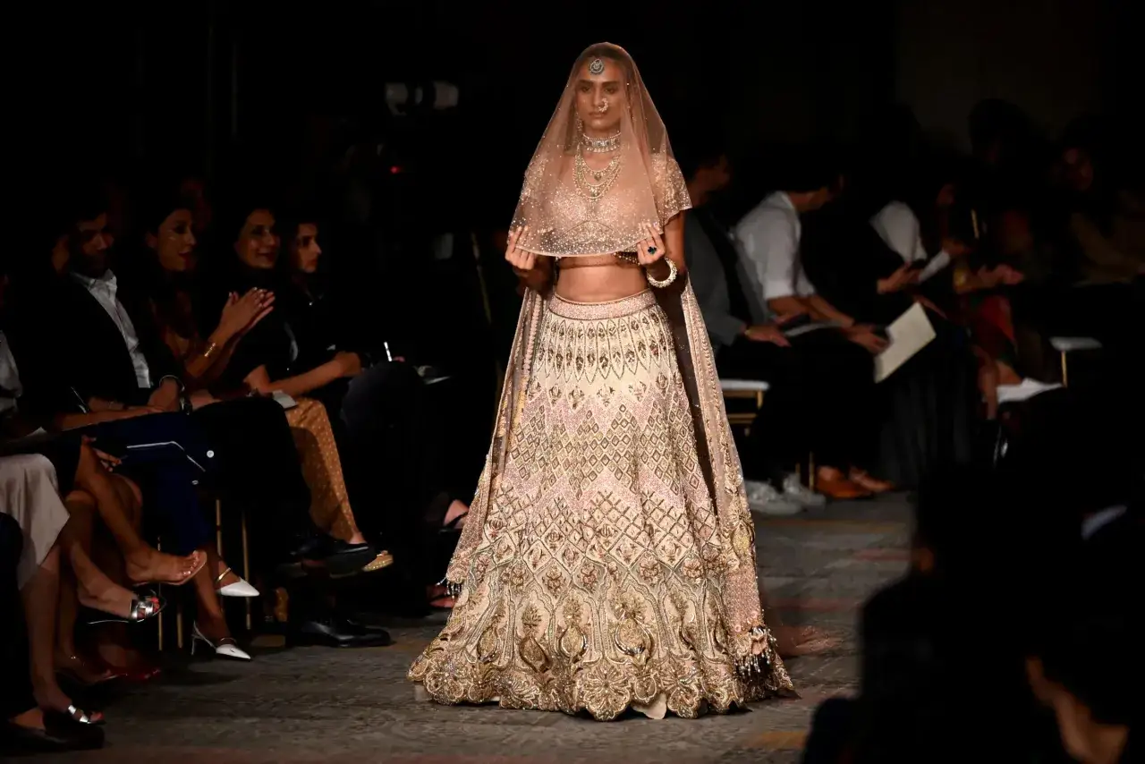 Modella sfila con un lehenga scintillante, un abito da sposa ispirato all'anant ambani matrimonio.