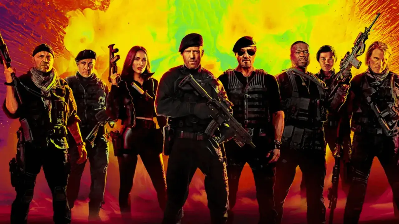 Il team de I Mercenari 4, con Sylvester Stallone e Jason Statham in primo piano, pronto all'azione con armi e giubbotti tattici.