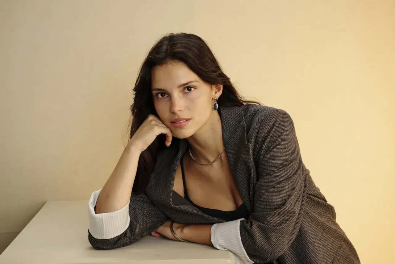 Indi Navarrete, attrice di film e programmi TV, posa con un blazer grigio e un'espressione pensierosa.