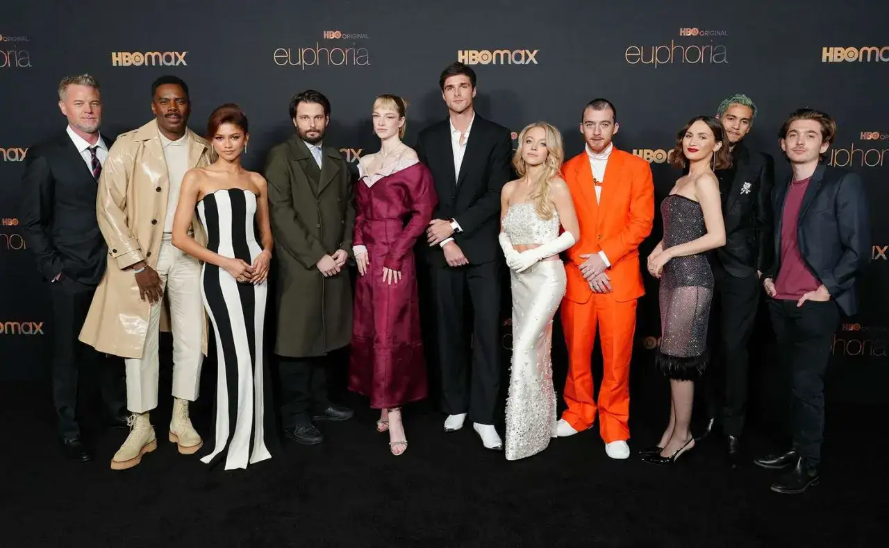 Il cast di Euphoria posa sul tappeto nero, con Zendaya in abito a righe, Sydney Sweeney scintillante e Jacob Elordi in completo scuro.