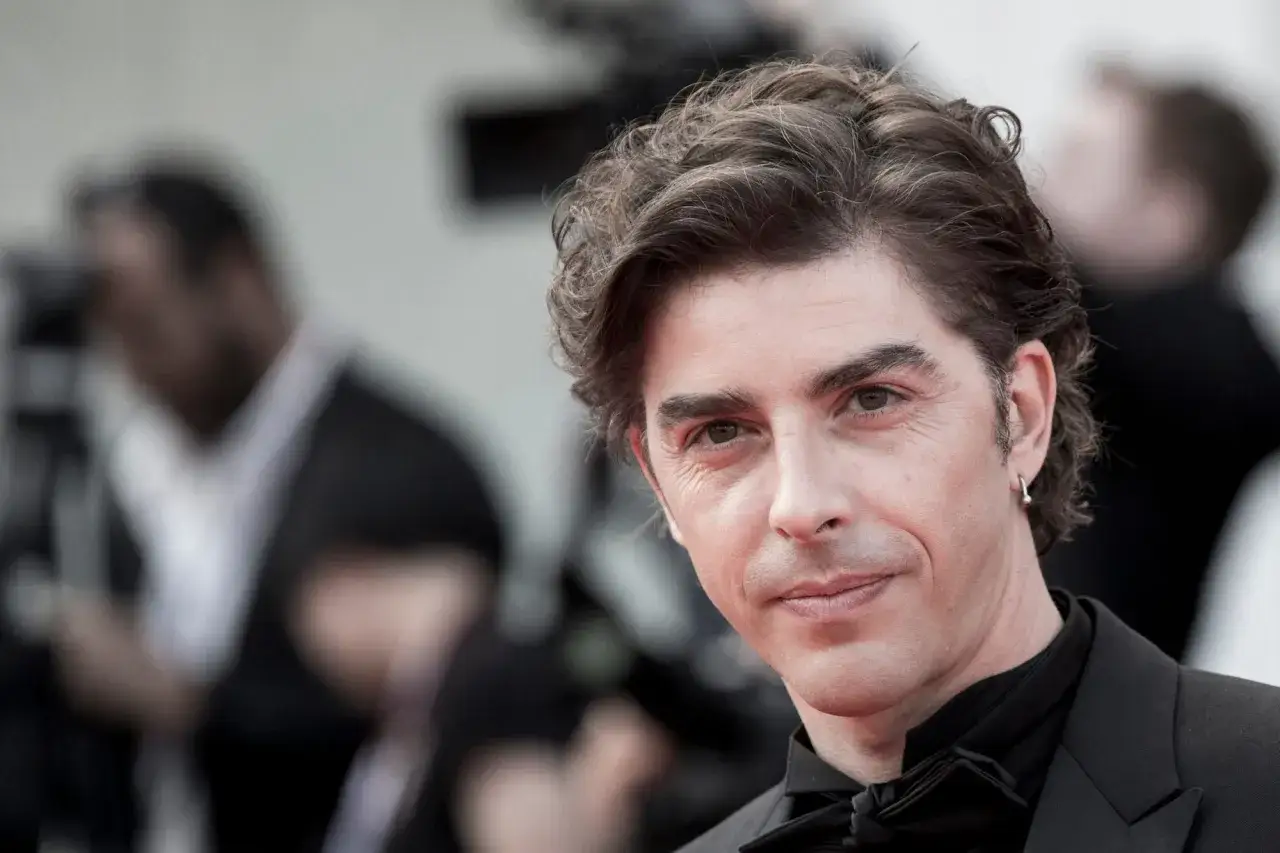 Michele Riondino, protagonista di molti film e programmi TV, con un sorriso enigmatico.