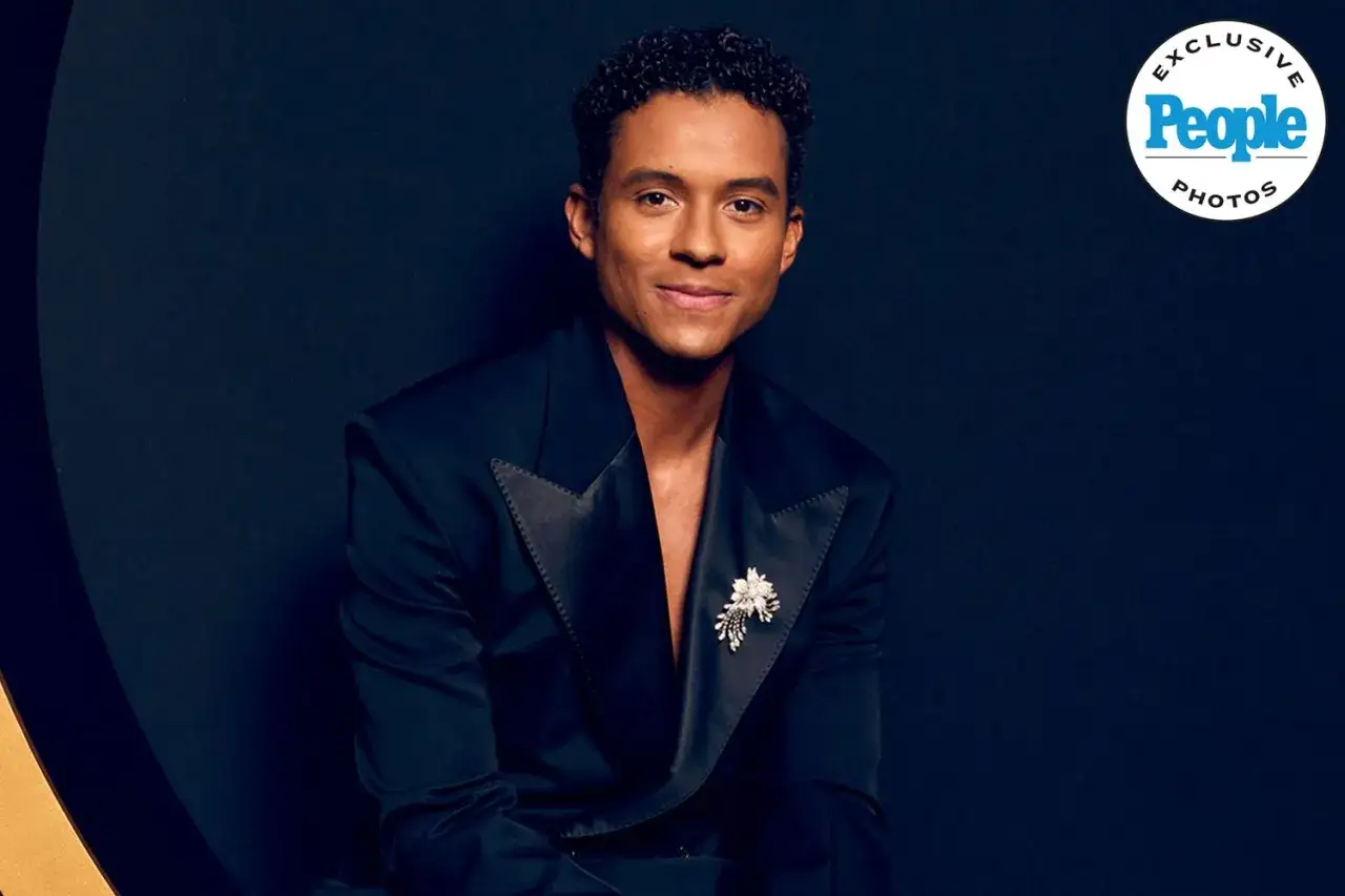 Jaafar Jackson, protagonista del film su Michael Jackson, posa con un elegante abito scuro e una spilla floreale.