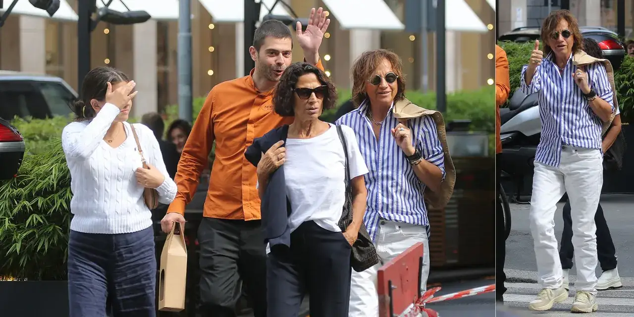Gianna Nannini, la sua compagna Carla e un amico passeggiano per strada. Carla, con occhiali da sole, sembra pensierosa.